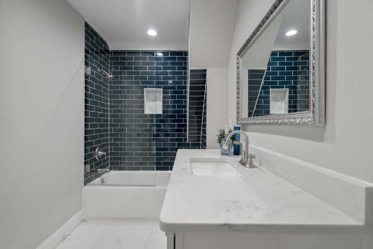 A bathroom remodeled by Veteran Built Homes featuring blue tiles on the walls and white countertops, creating a clean and modern aesthetic.