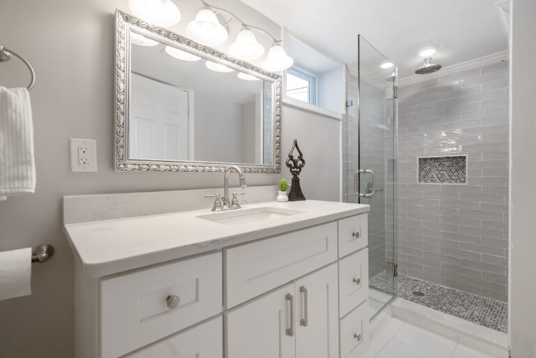 Elegant bathroom in Washington, D.C. with white cabinetry and a modern shower, remodeled by Veteran Built Homes.