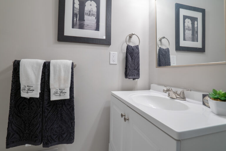 Stylish bathroom in Washington, D.C., remodeled by Veteran Built Homes, showcasing a sink, mirror, and towels in a contemporary design.