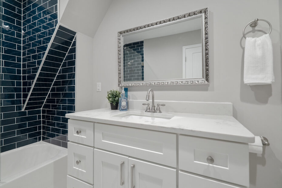 A modern bathroom renovation completed by Veteran Built Homes in Northern Virginia showcasing blue tiles and white cabinets, combining color and functionality in the design.