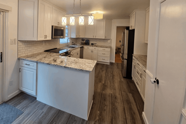 Elegant kitchen remodel in Northern Virginia by Veteran Built Homes featuring white shaker cabinets, granite countertops, subway tile backsplash, modern pendant lighting, and luxury vinyl plank flooring.