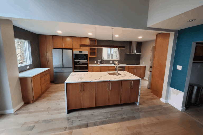 Contemporary kitchen remodel in Northern Virginia by Veteran Built Homes featuring custom wood cabinetry, quartz waterfall island, stainless steel appliances, and modern pendant lighting.