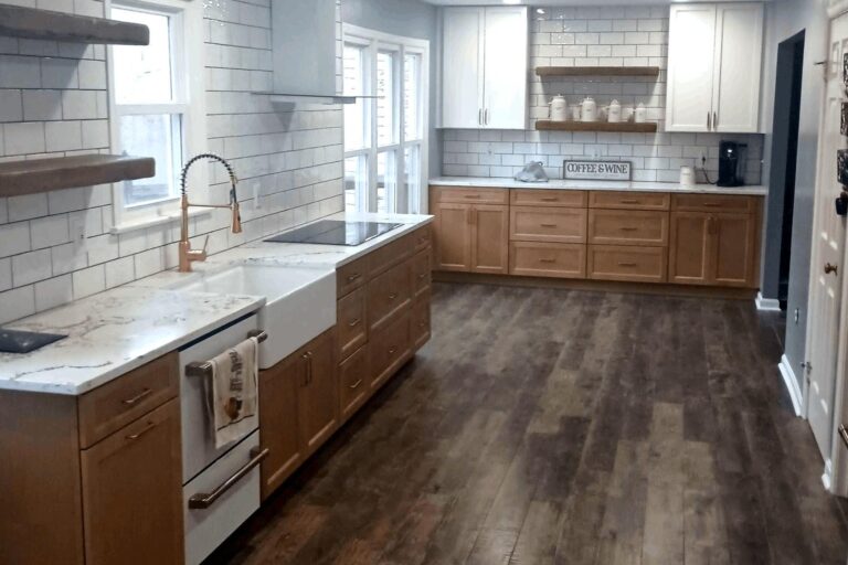 Modern kitchen remodel in Northern Virginia by Veteran Built Homes featuring white subway tile backsplash, farmhouse sink, natural wood cabinets, and wide plank hardwood floors.